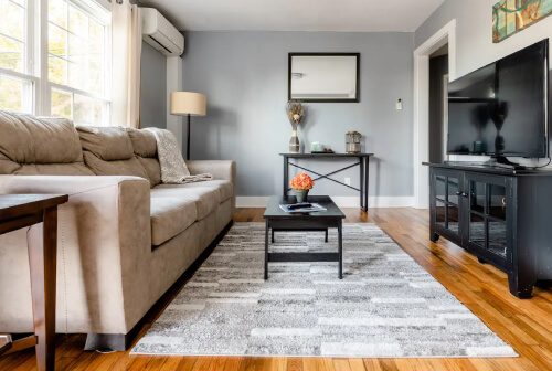 living room with a black leather couch and coffee table in the middle of the room